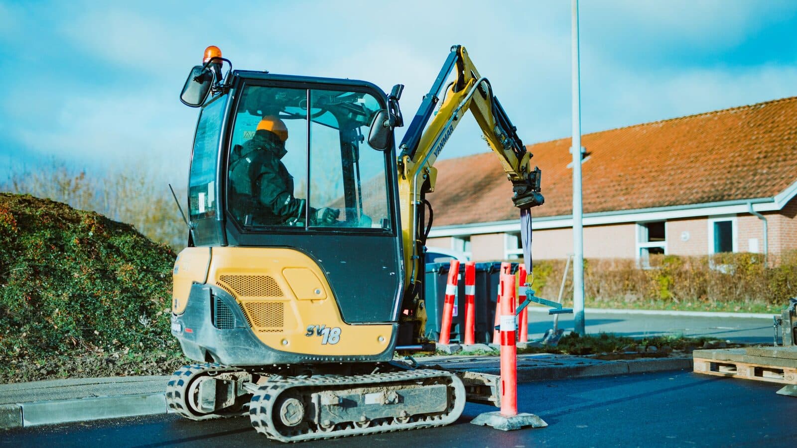 Operator lucrând cu un miniexcavator